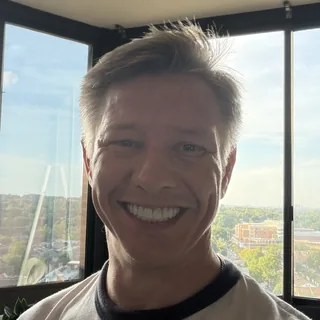 Nic O'Connor, smiling, in front of a window